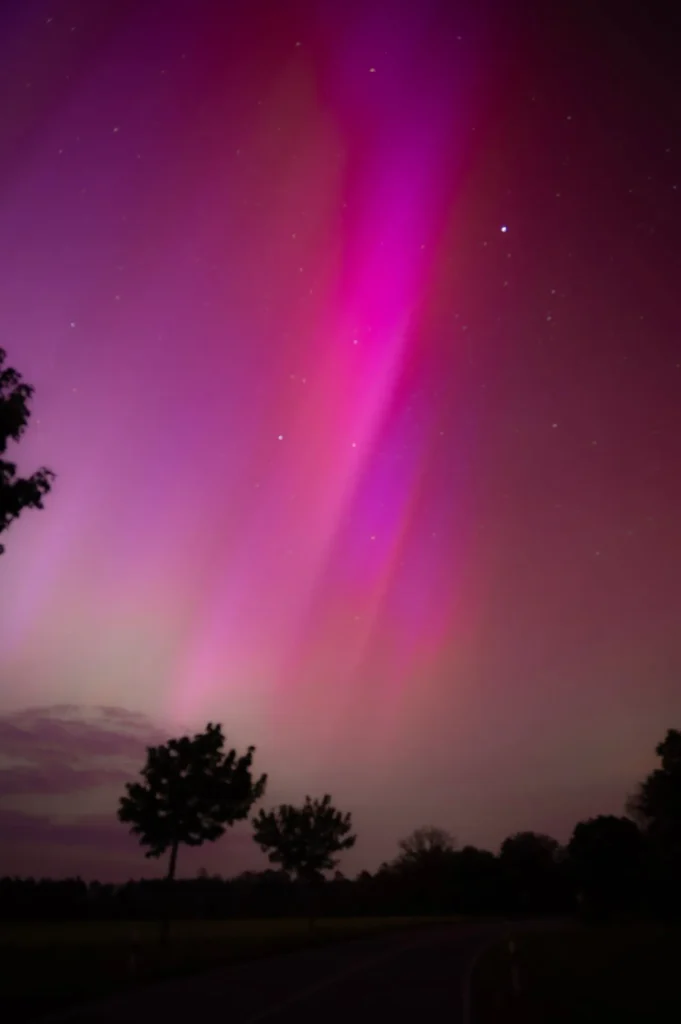 Multi-color aurora borealis with pink and green over Norway snow landscape