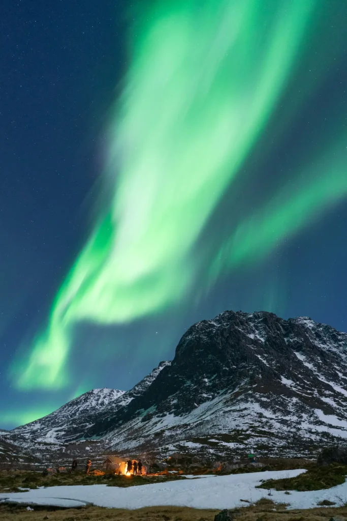 Aurora borealis over Norwegian fjord with mountains and reflection